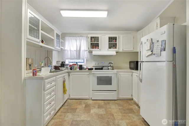 a kitchen with white cabinets and white appliances