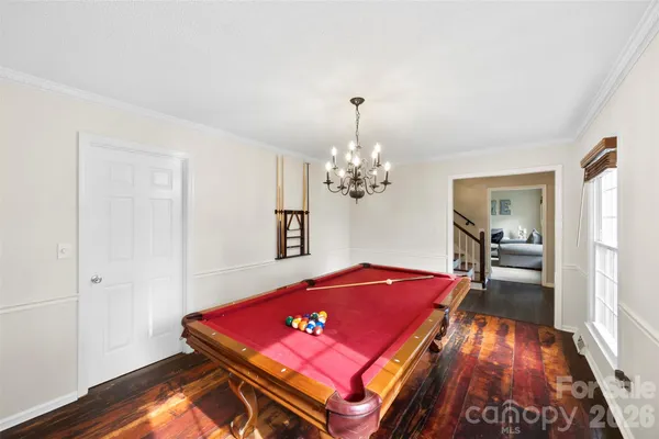 a room with pool table and wooden floor