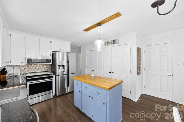 a kitchen with refrigerator cabinets and wooden floor