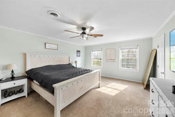 a bedroom with a bed and a flat tv screen on the dresser