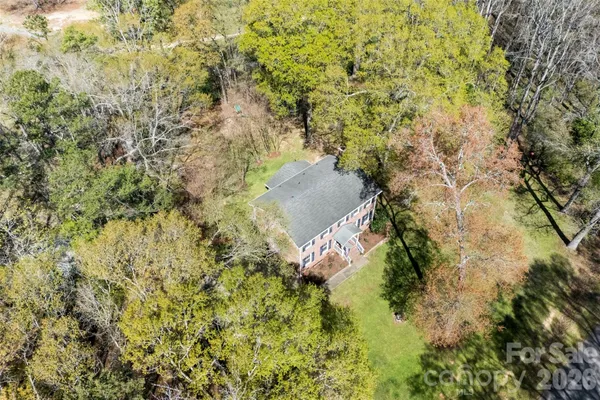 a aerial view of a house with a yard and large trees