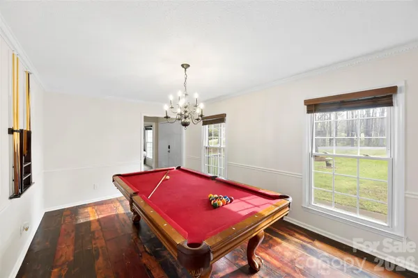 a room with pool table and windows