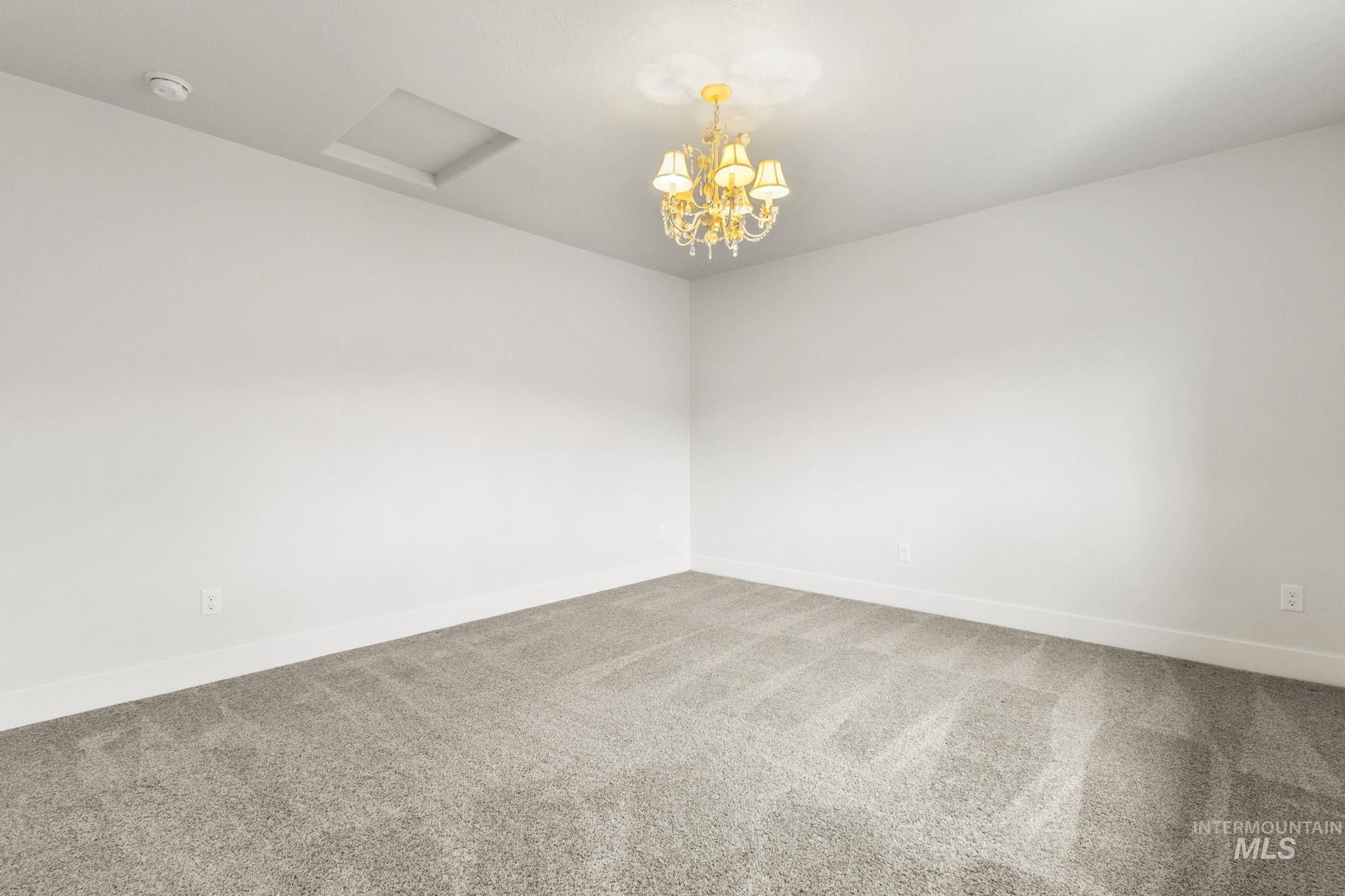 18293 North Streams Edge Way Boise, ID 83714 - Photo 27 of 50 Carpeted empty room featuring hanging lights and baseboards