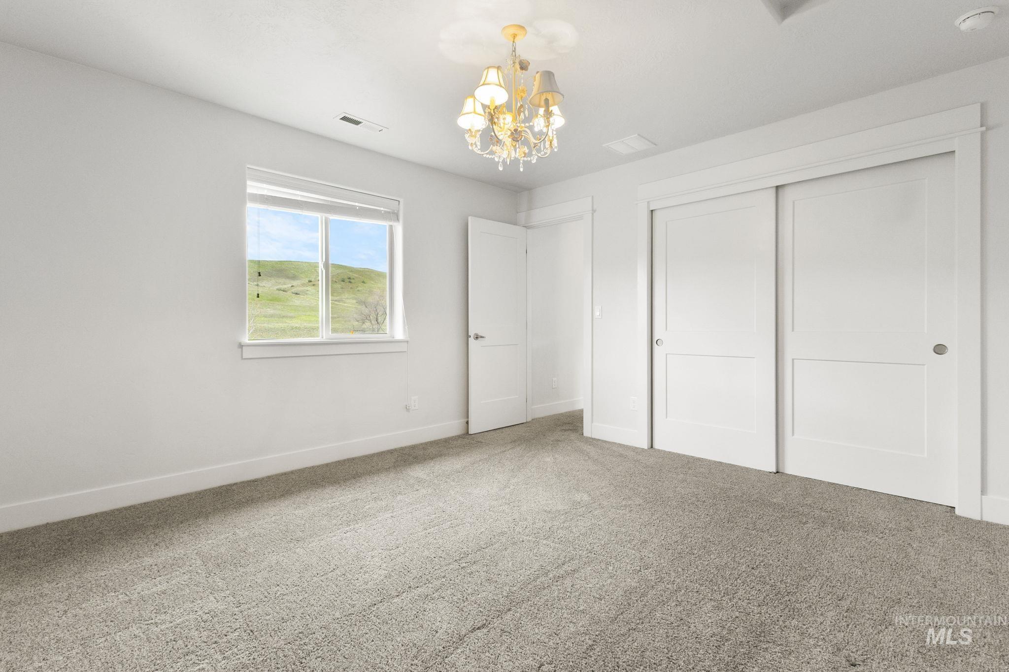 18293 North Streams Edge Way Boise, ID 83714 - Photo 28 of 50 Unfurnished bedroom featuring a chandelier, carpet floors, and a closet