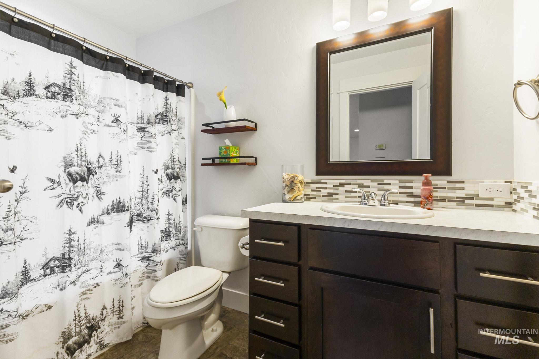 18293 North Streams Edge Way Boise, ID 83714 - Photo 30 of 50 Bathroom with vanity, a shower with shower curtain, and decorative backsplash