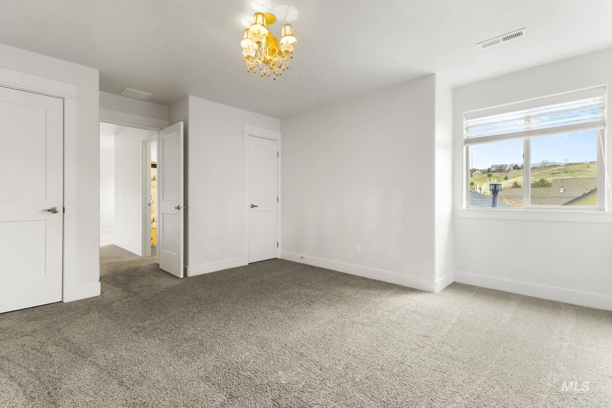 18293 North Streams Edge Way Boise, ID 83714 - Photo 32 of 50 Unfurnished bedroom featuring carpet and a chandelier