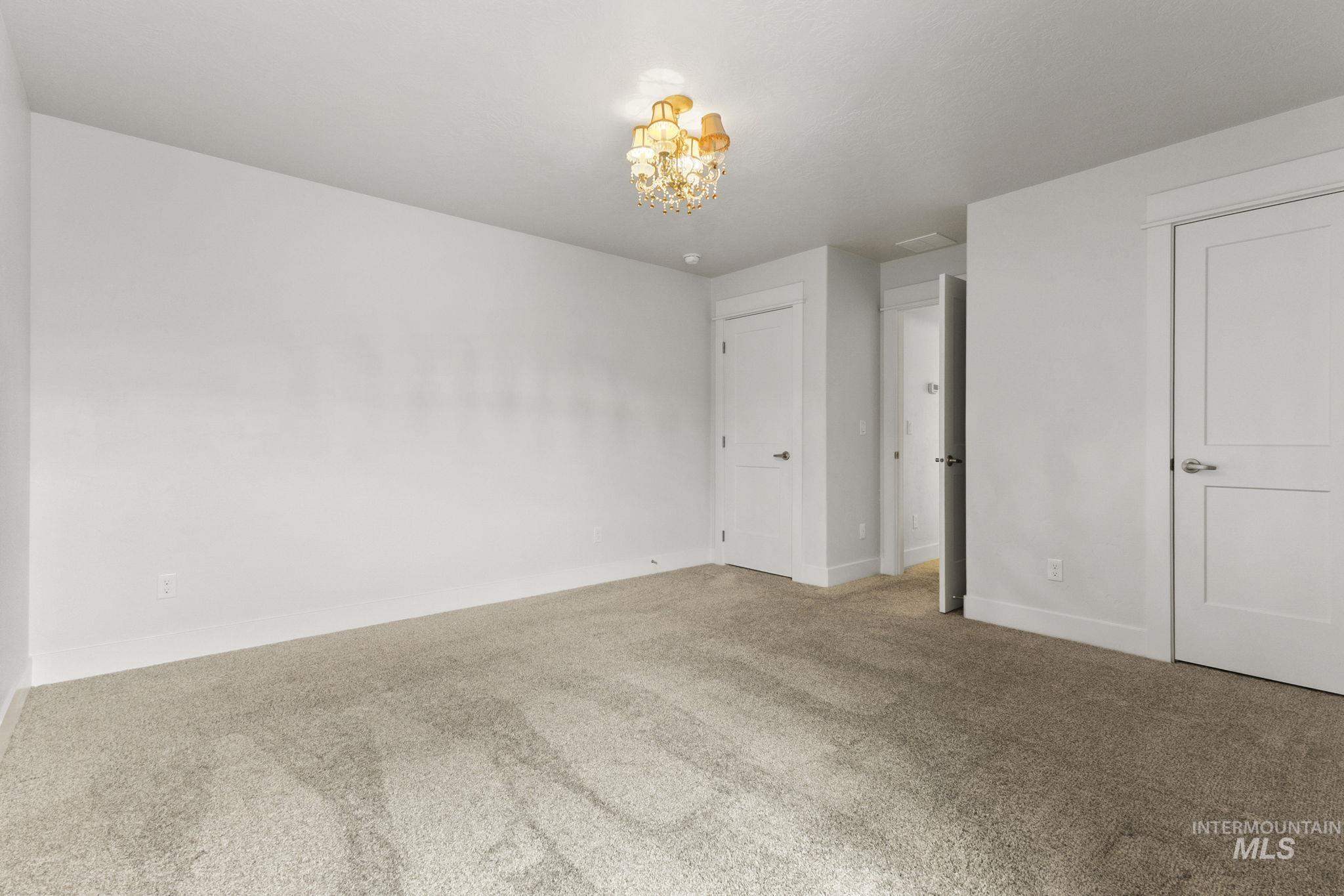 18293 North Streams Edge Way Boise, ID 83714 - Photo 33 of 50 Unfurnished bedroom featuring carpet floors and hanging lights