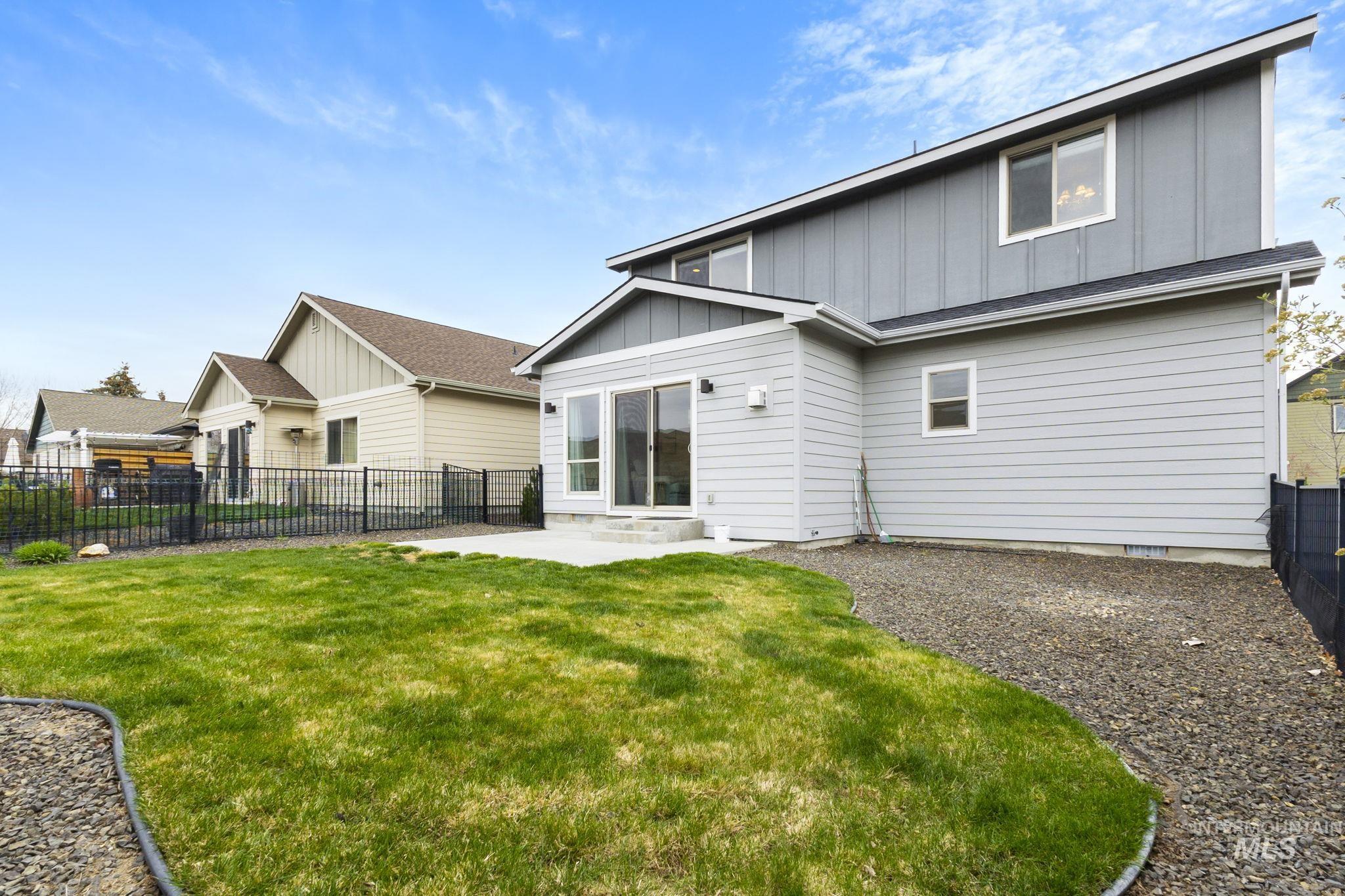 18293 North Streams Edge Way Boise, ID 83714 - Photo 35 of 50 Back of property with board and batten siding, a fenced backyard, and a patio area