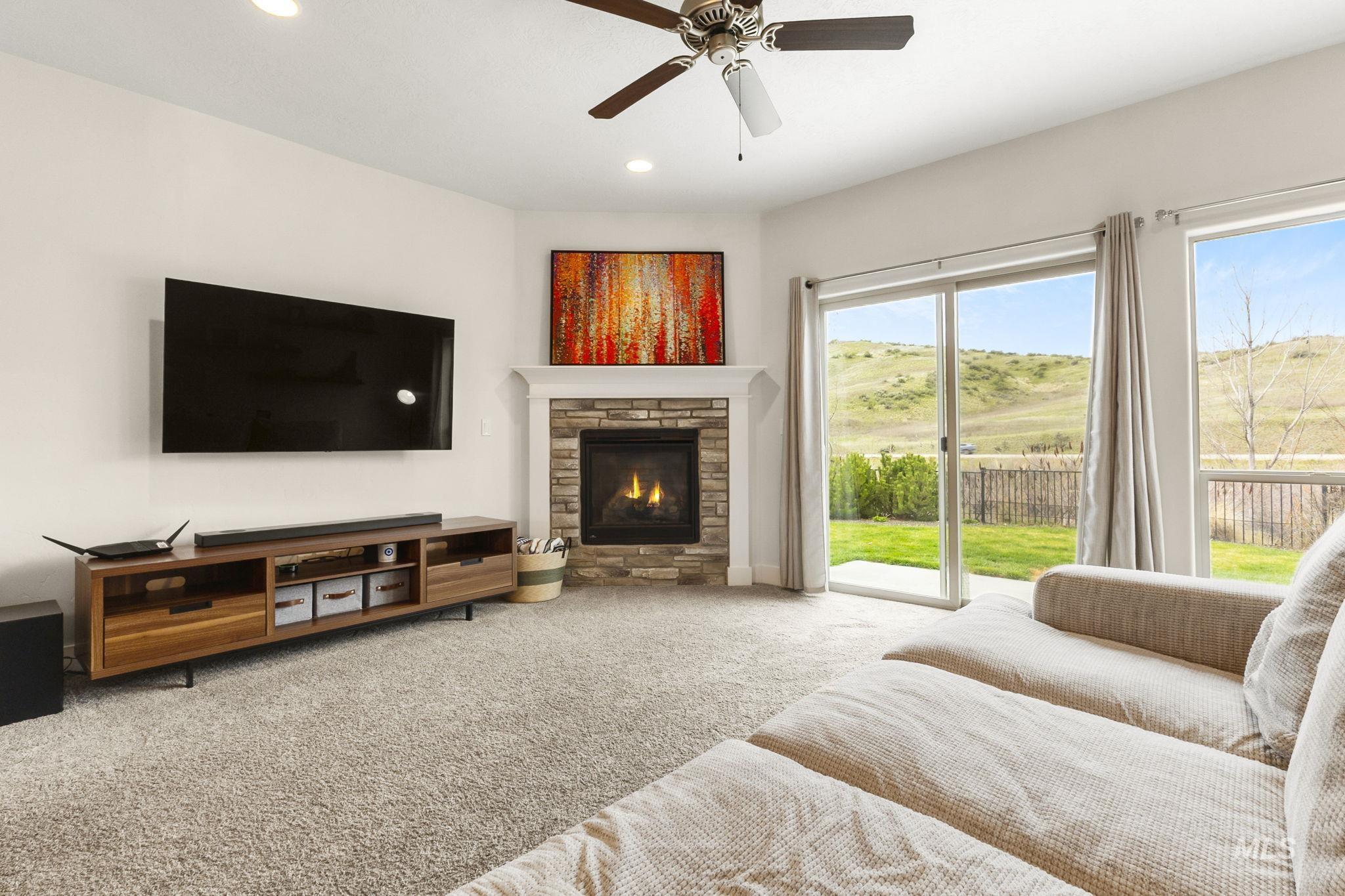 18293 North Streams Edge Way Boise, ID 83714 - Photo 8 of 50 Carpeted living room with a ceiling fan, a stone fireplace, and recessed lighting