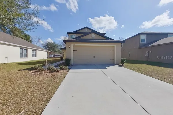 a view of a house with a yard and garage
