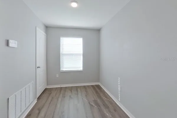 wooden floor in an empty room with a window