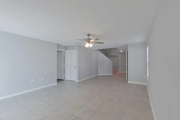 a view of an empty room with a ceiling fan