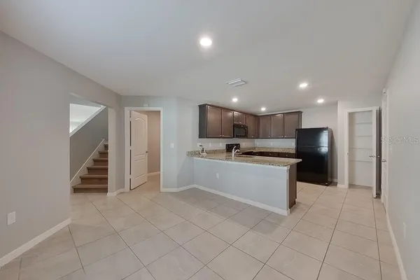 a large white kitchen with a sink and dishwasher a refrigerator with white cabinets
