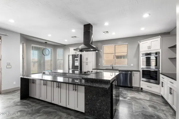 a kitchen with stainless steel appliances granite countertop a stove a refrigerator and a sink