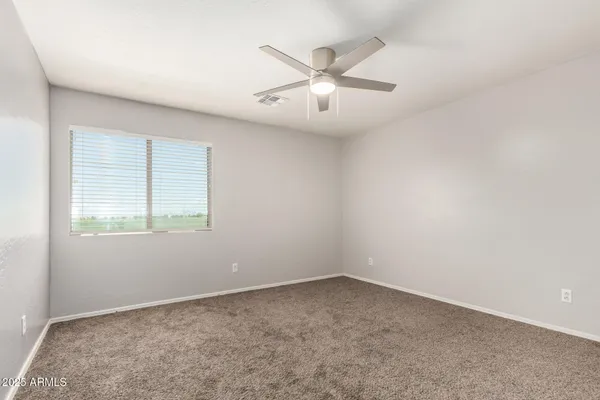 an empty room with chandelier fan