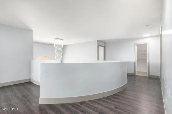 an empty room with wooden floor and a ceiling fan