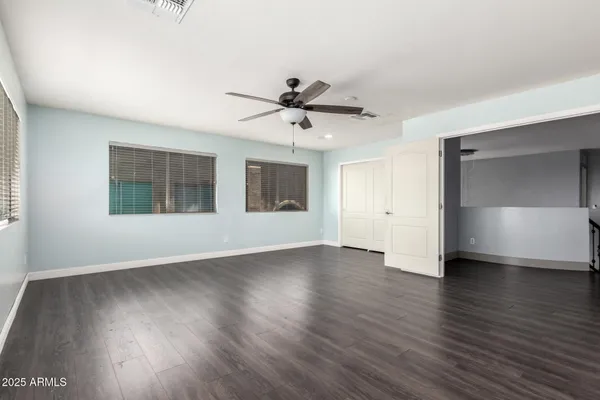 an empty room with wooden floor and windows