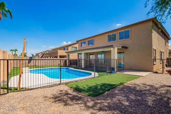 a view of a house with a swimming pool and a yard