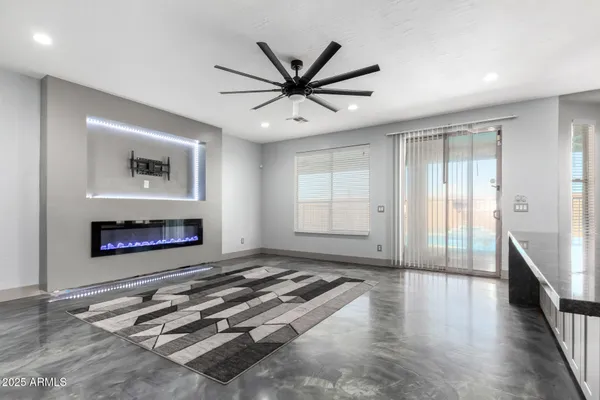 an empty room with windows and fireplace