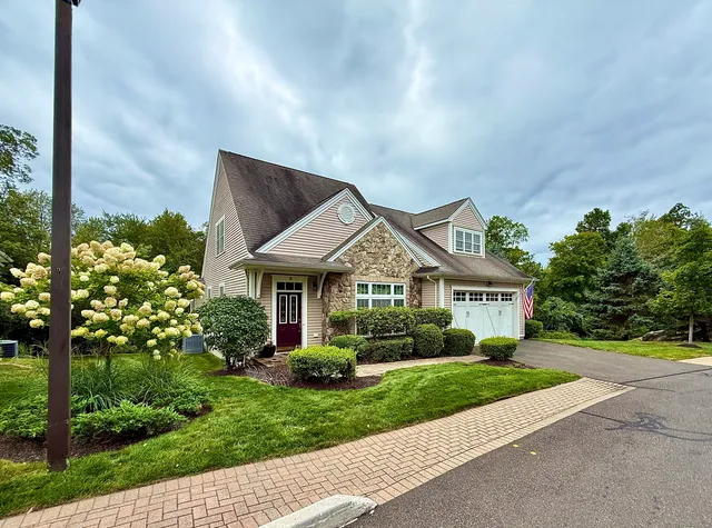 a front view of a house with a yard and potted plants