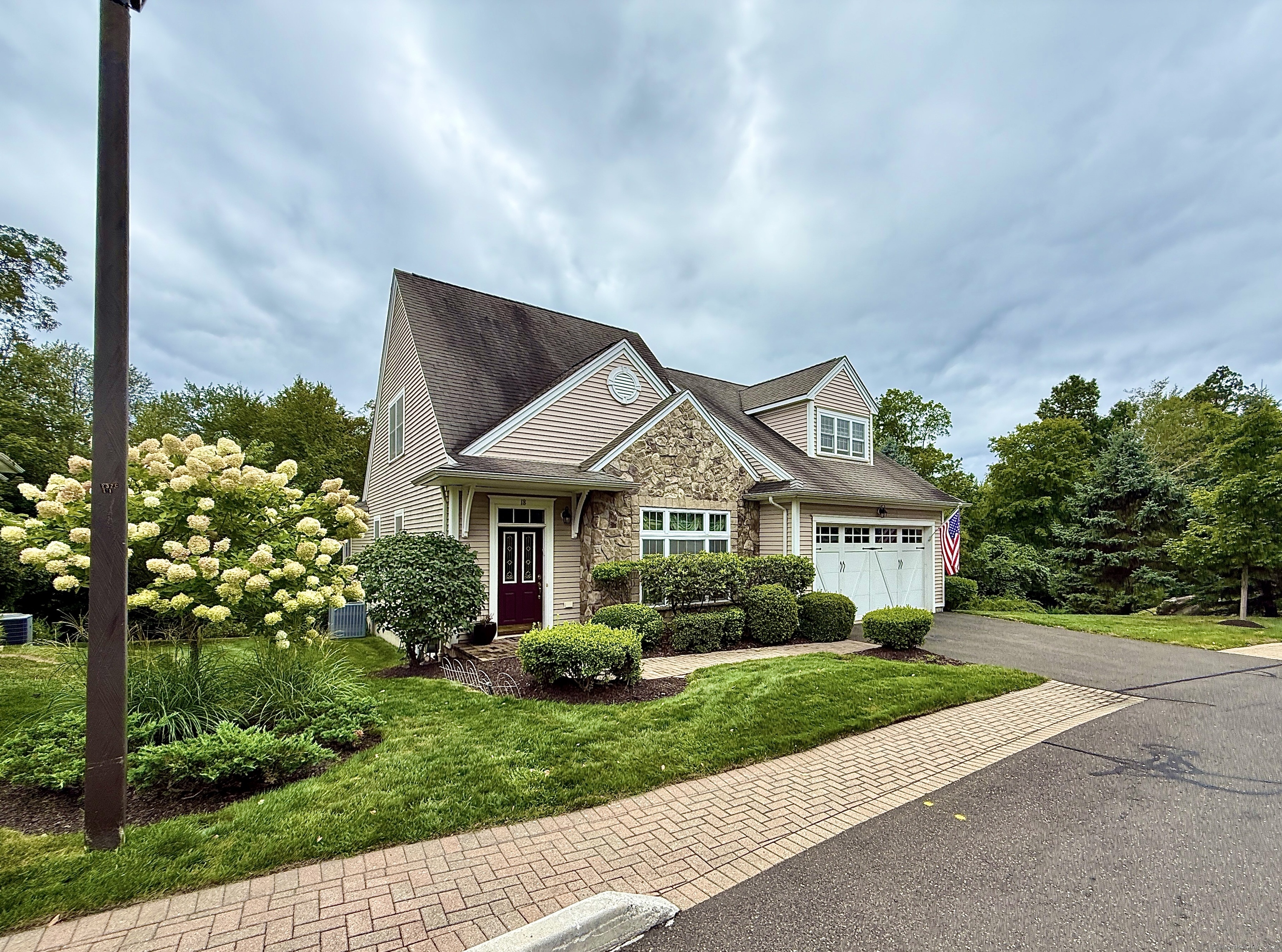 18 Fieldstone Lane, Unit 18 Beacon Falls, CT 06403 - Photo 1 of 40 a front view of a house with a yard and potted plants
