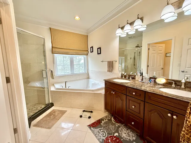 a spacious bathroom with a tub sink and mirror