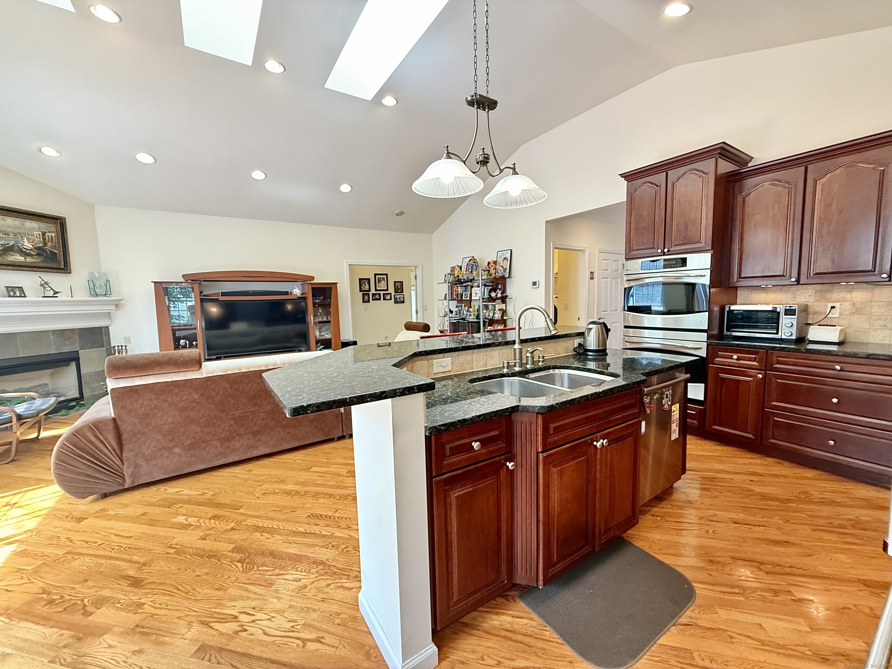 18 Fieldstone Lane, Unit 18 Beacon Falls, CT 06403 - Photo 32 of 40 a large kitchen with stainless steel appliances granite countertop a stove a sink dishwasher and a refrigerator with wooden cabinets