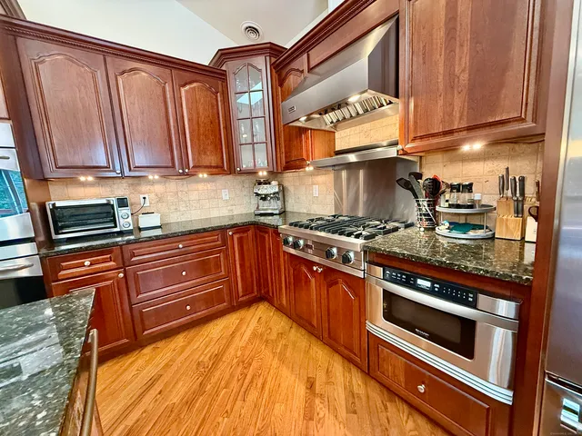 a kitchen with wooden cabinets and a stove top oven