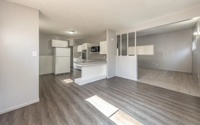 a view of a kitchen with wooden floor and electronic appliances