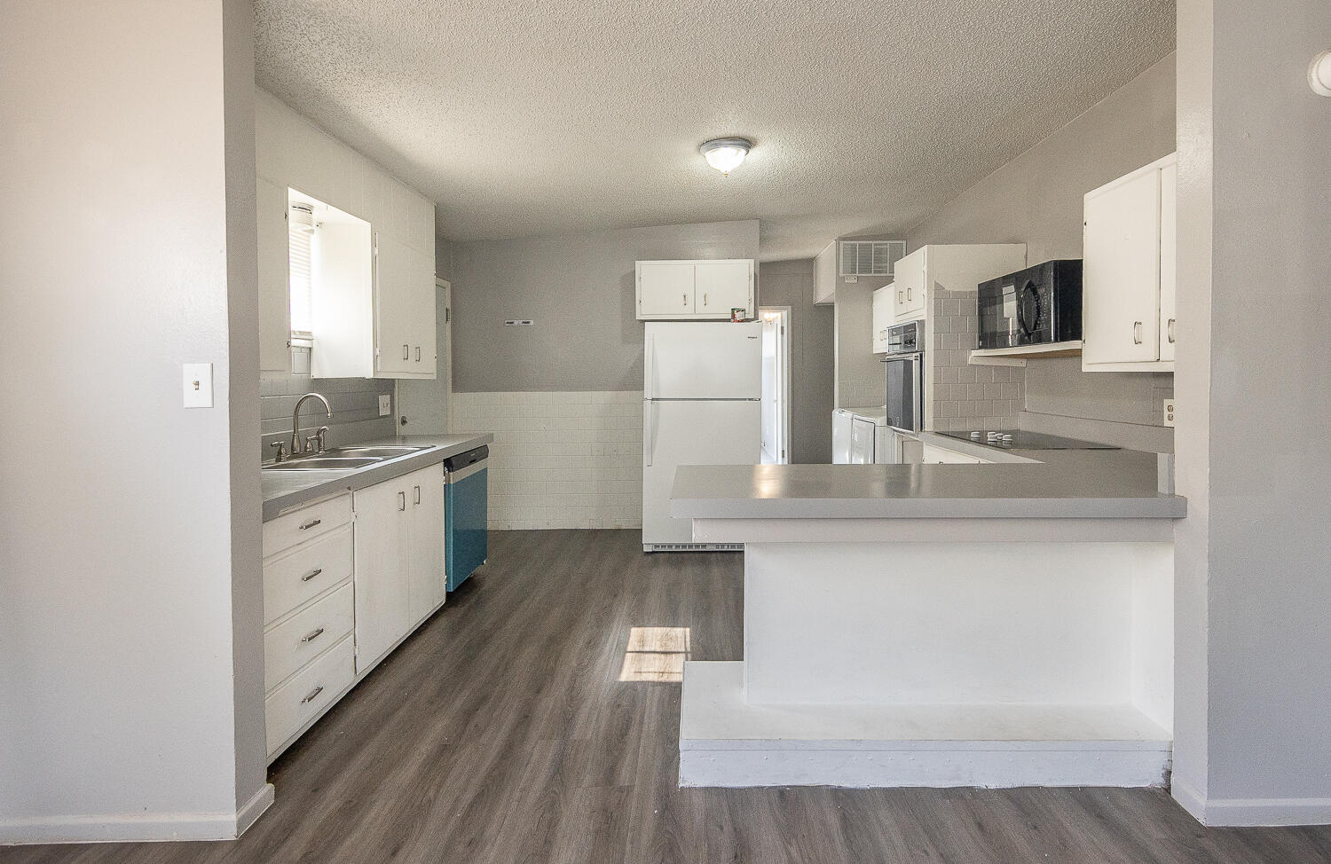 4409 44th Street Lubbock, TX 79414 - Photo 9 of 22 a large white kitchen with stainless steel appliances granite countertop a lot of counter space and wooden floor