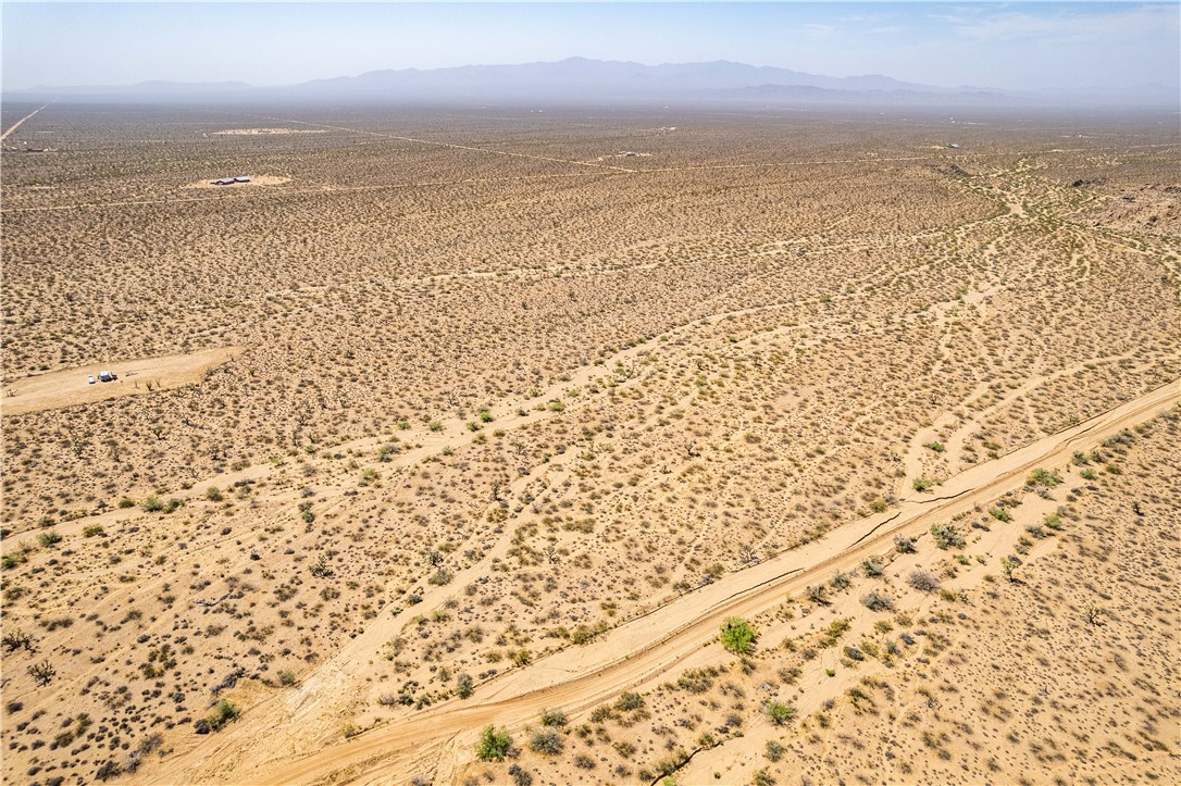 0 East Arroyo Road Yucca, AZ 86438 - Photo 2 of 25 Expansive desert landscape with a clear sky and distant mountains
