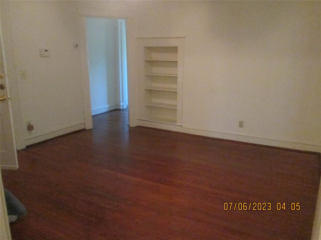 203 North Colson Street, Unit 4 Dallas, TX 75246 - Photo 7 of 15 Empty room with built in features, wood finished floors, and baseboards