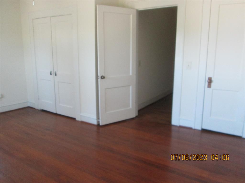203 North Colson Street, Unit 4 Dallas, TX 75246 - Photo 9 of 15 Unfurnished bedroom with wood finished floors, a closet, and baseboards