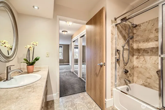 a bathroom with a granite countertop toilet a sink and a mirror