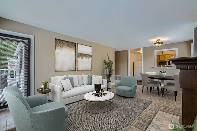 a view of empty room with wooden floor and kitchen view