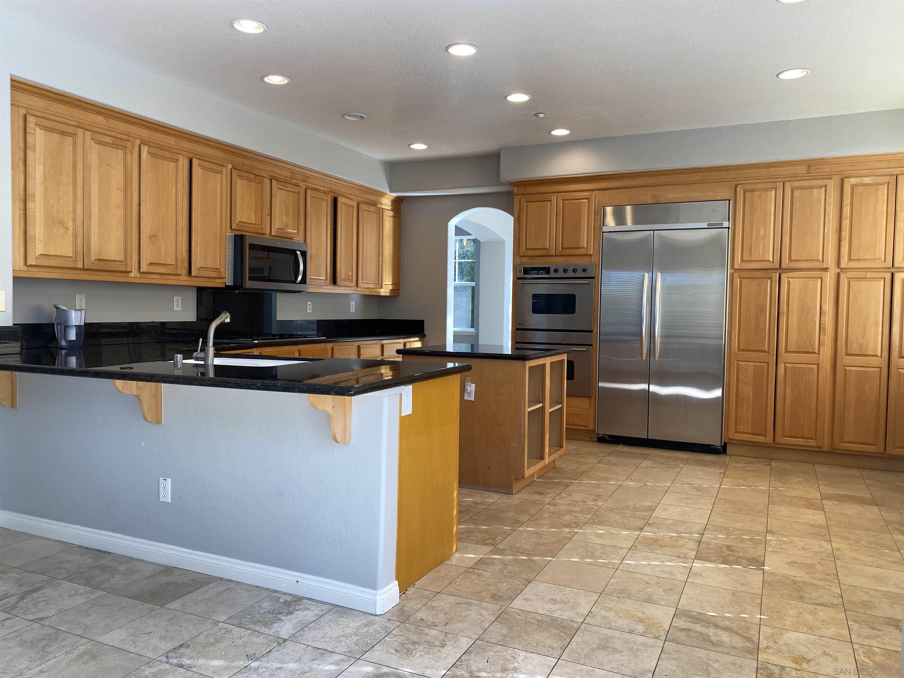513 Park Lane Encinitas, CA 92024 - Photo 12 of 41 a kitchen with stainless steel appliances granite countertop a refrigerator a stove a sink and a microwave