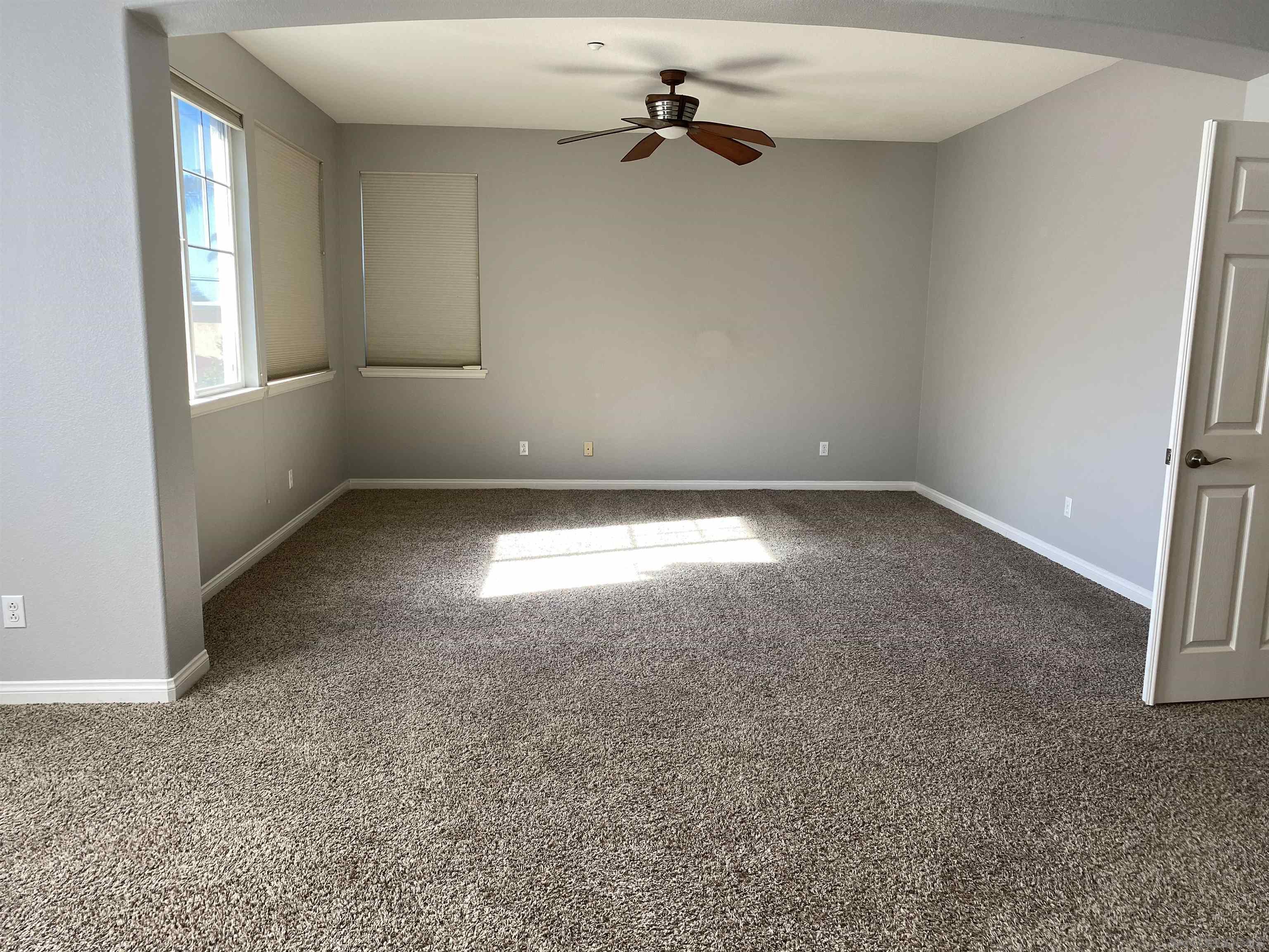 513 Park Lane Encinitas, CA 92024 - Photo 17 of 41 an empty room with windows and chandelier fan