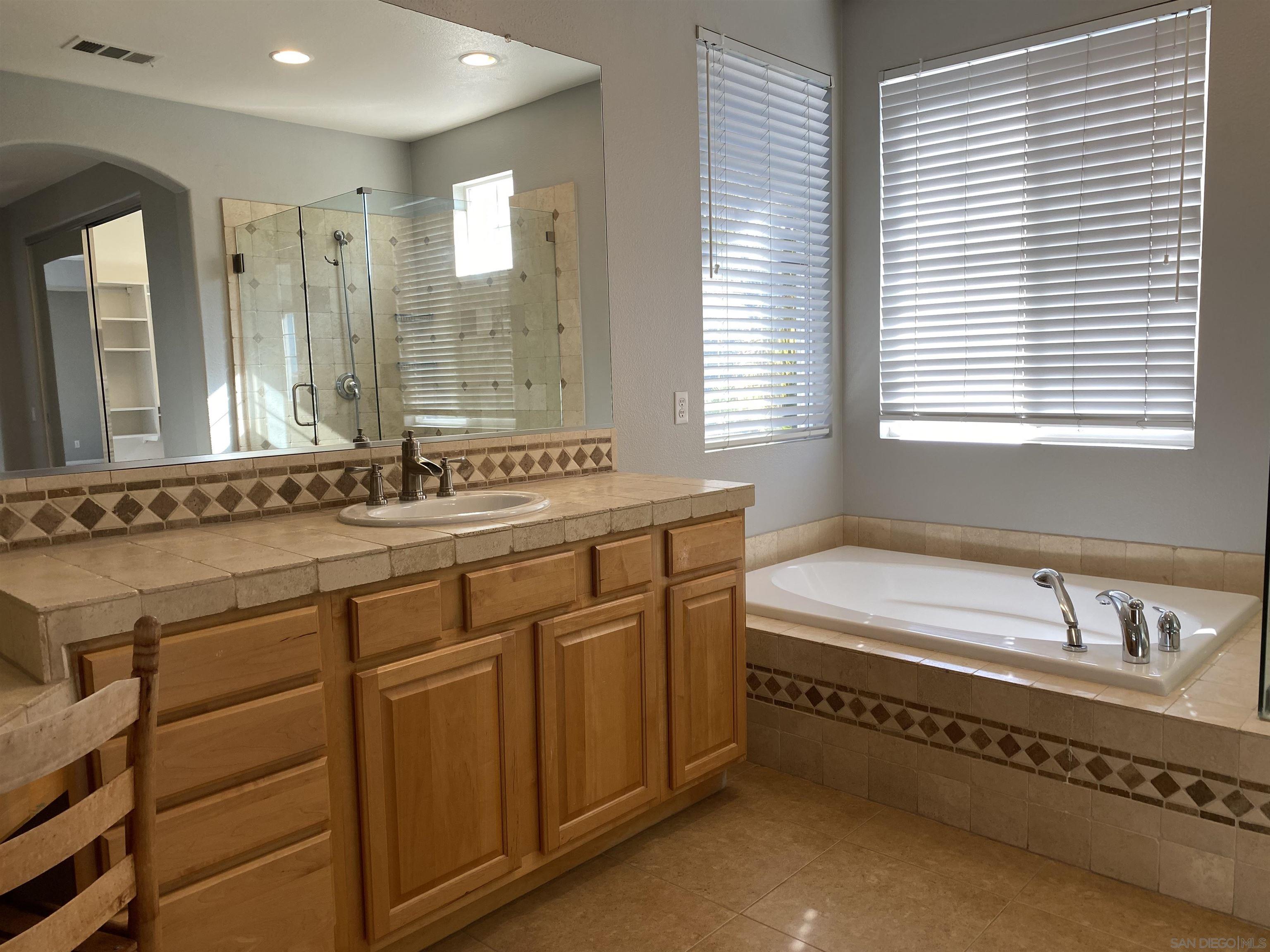 513 Park Lane Encinitas, CA 92024 - Photo 21 of 41 a spacious bathroom with a double vanity sink large mirror and a bathtub