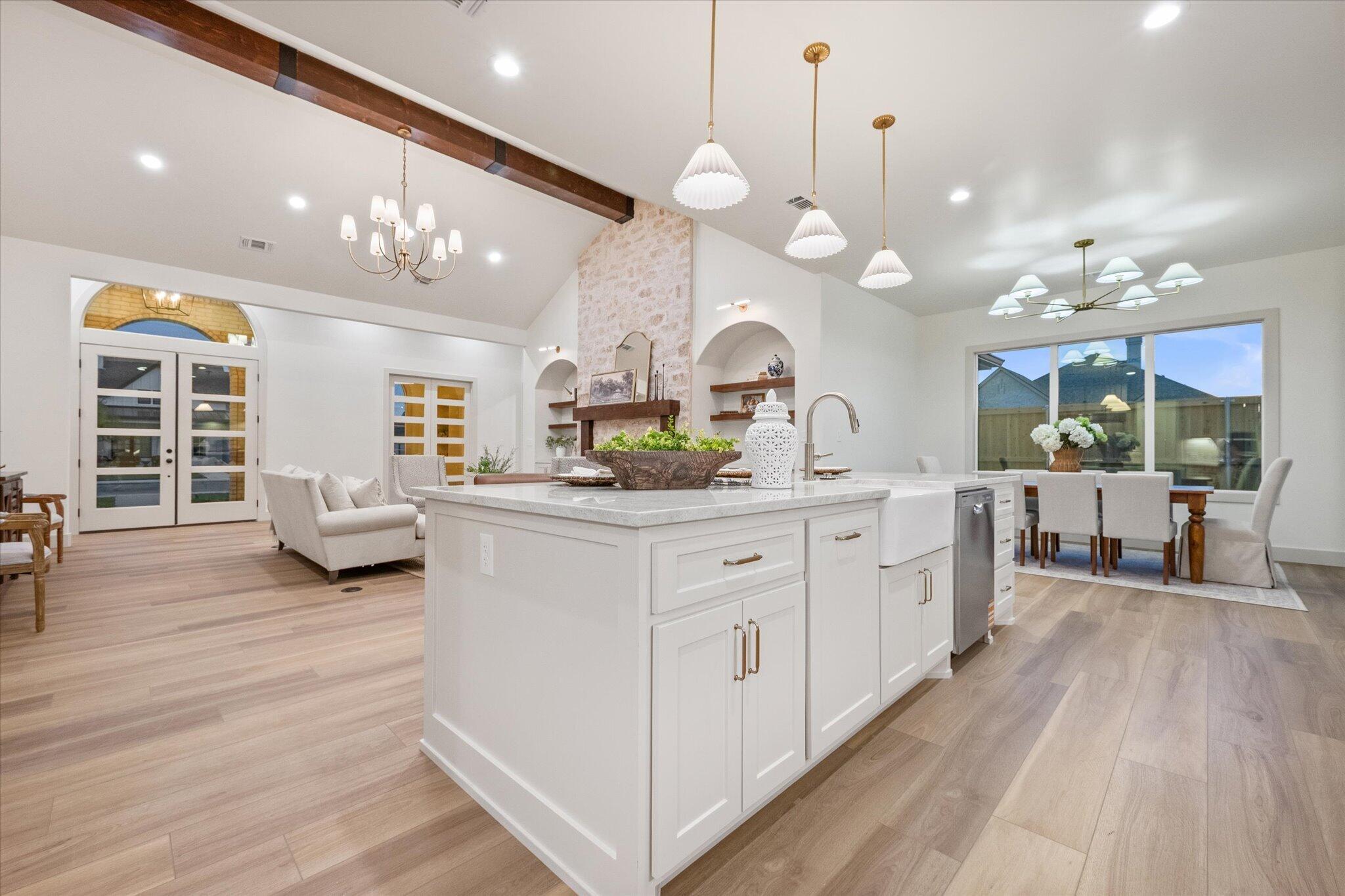 4622 138th Place Lubbock, TX 79424 - Photo 14 of 48 a large white kitchen with a large island oven a stove and a wooden floors