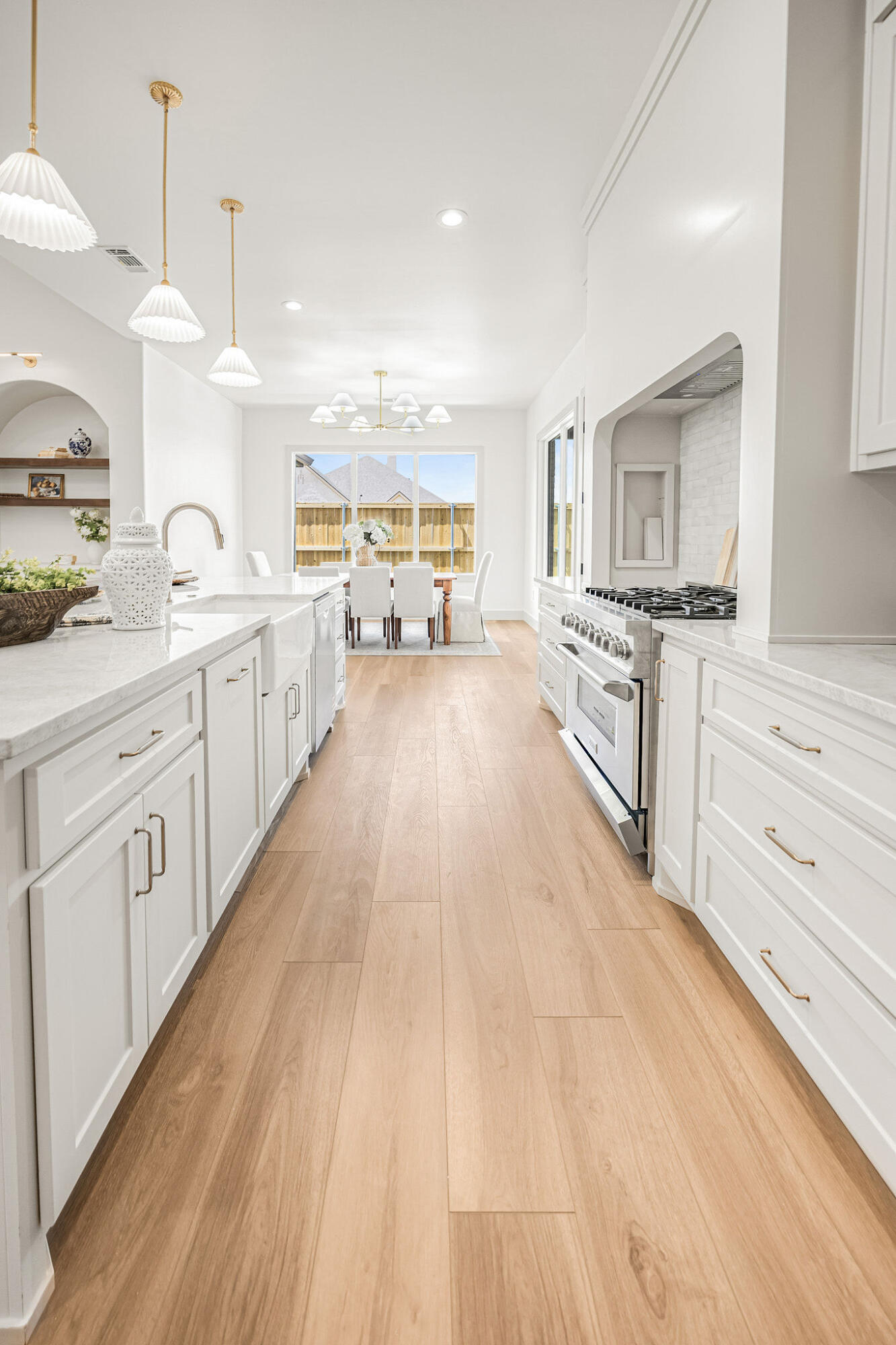 4622 138th Place Lubbock, TX 79424 - Photo 16 of 48 a large kitchen with kitchen island a sink dishwasher stove and white cabinets with wooden floor