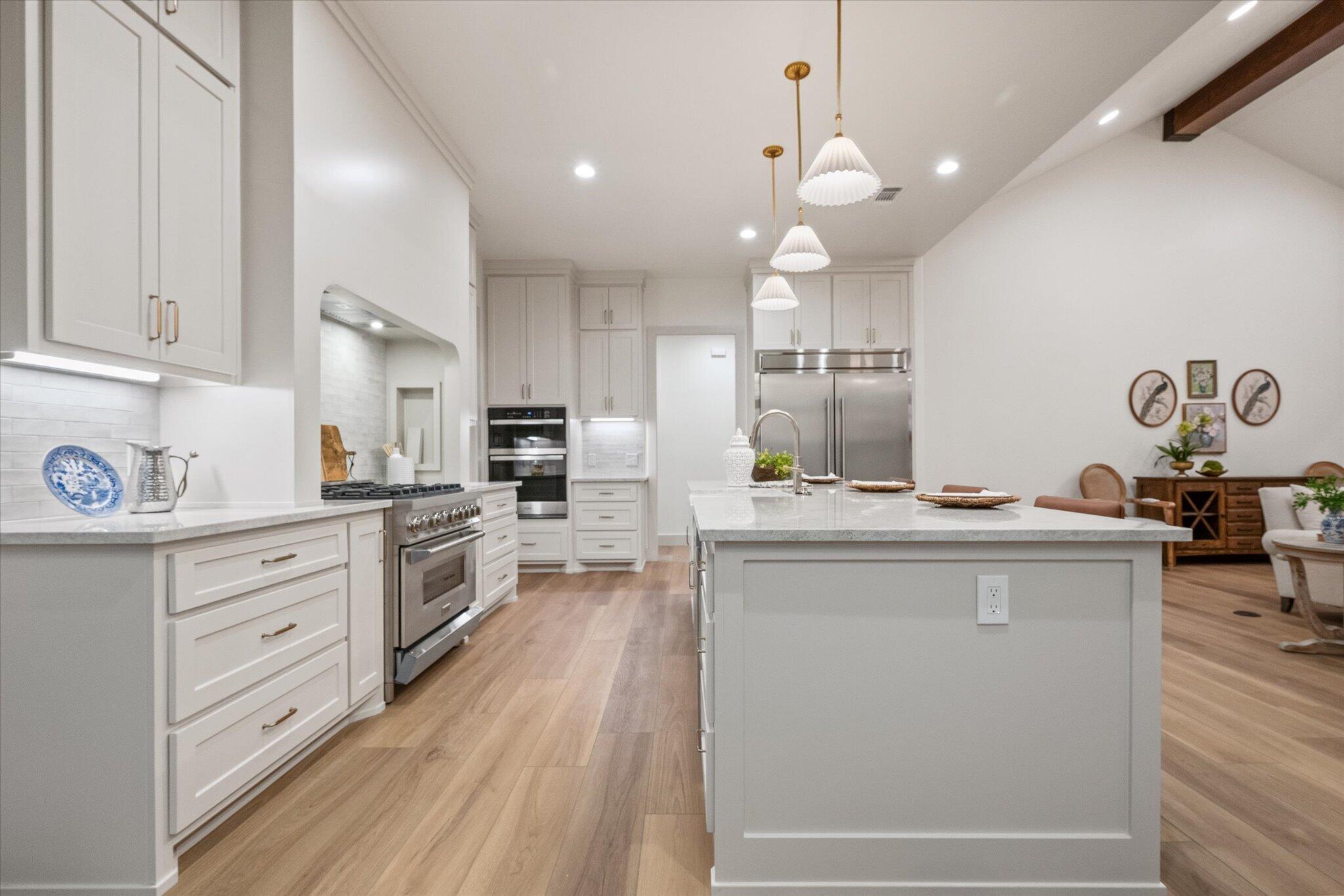 4622 138th Place Lubbock, TX 79424 - Photo 17 of 48 a kitchen with kitchen island granite countertop a sink cabinets and wooden floor