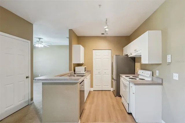 a kitchen with kitchen island a sink stove and refrigerator