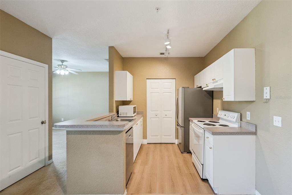 825 Grand Regency Point, Unit 103 Altamonte Springs, FL 32714 - Photo 6 of 20 a kitchen with kitchen island a sink stove and refrigerator