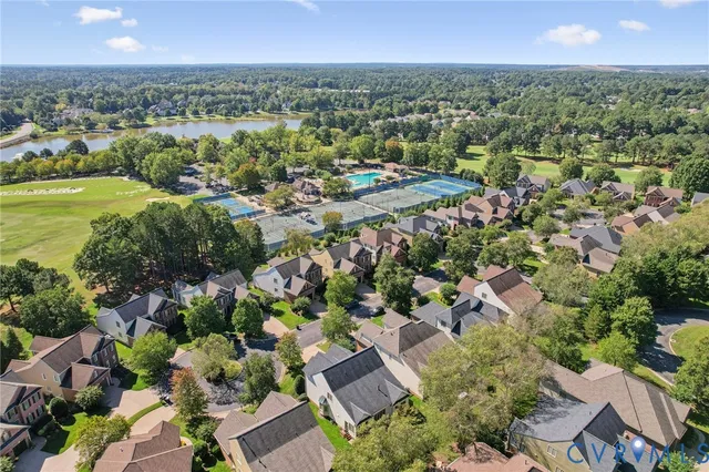 an aerial view of residential houses with outdoor space and lake view