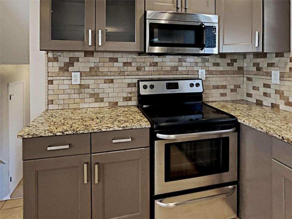3148 Thrasher Circle Decatur, GA 30032 - Photo 18 of 20 a kitchen with stainless steel appliances granite countertop stove microwave and cabinets