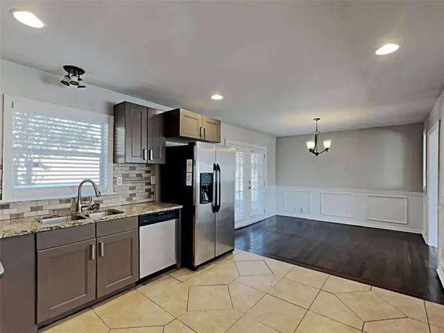 a kitchen with stainless steel appliances a refrigerator sink and cabinets
