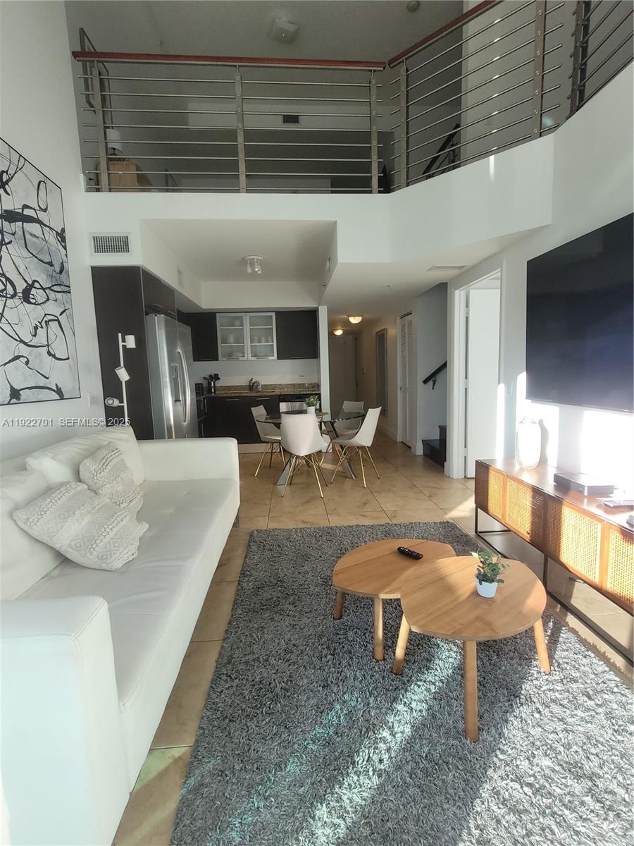 41 Southeast 5th Street, Unit 710 Miami, FL 33131 - Photo 5 of 14 a living room with furniture a rug and a fireplace