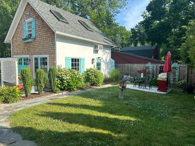 a view of an house with backyard and sitting area