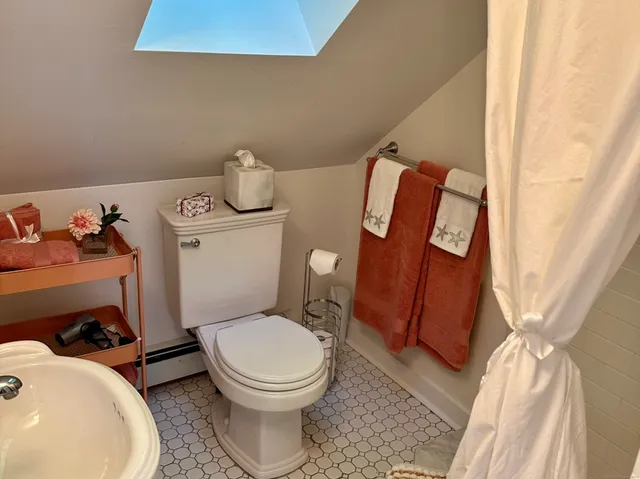 a white toilet sitting next to a bathroom sink and a tub