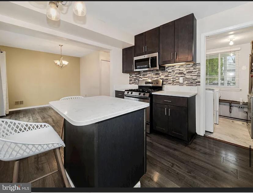 9481 Farewell Road Columbia, MD 21045 - Photo 10 of 18 a kitchen with a sink a stove a microwave oven a refrigerator with a dining table and chairs